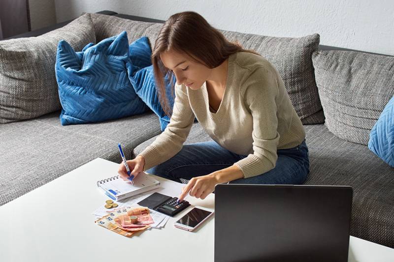 Frau mit Taschenrechner und Bargeld